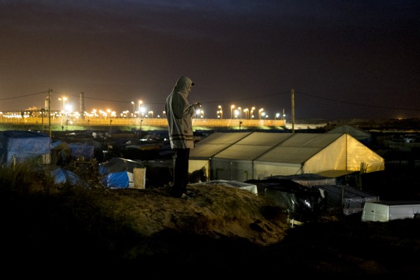 A man phones from the top of the central dune jungle to find some peace and privacy, in Calais, northern France on February 6, 2016