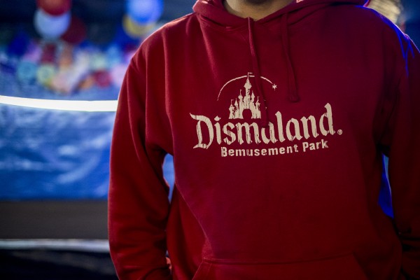 A man wearing a sweater DISMALAND created by Banksy. He gave migrants elements of ephemeral Bemusement park. In Calais, northern France, February 23, 2016 