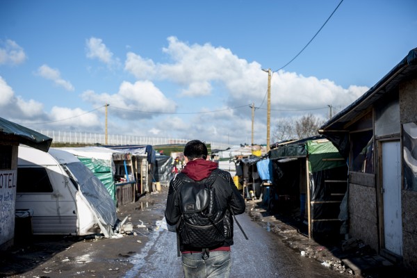 Un réfugié marche dans l’avenue principale de la jungle de Calais