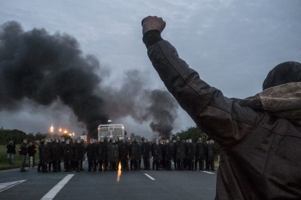 blocage devant le dépôt pétrolier de Douchy-les-Mines. La police arrive très tôt sur le blocage. Un manifestant, poing levé, proteste face à la police qui vient arrêter le blocage du dépôt pétrolier