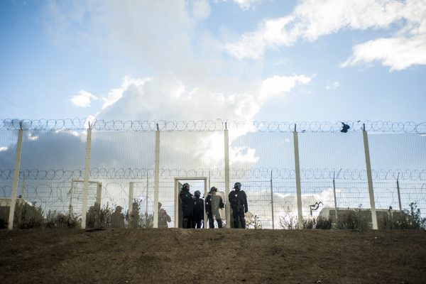 Manifestation en faveur des réfugiés. 1er octobre 2016 – Calais. D’autres policiers attendent le long du grillage qui protège la la rocade portuaire.