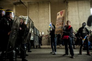 Manifestation en faveur des réfugiés. 1er octobre 2016 – Calais. Un soutien brandit une pancarte et jouera de la guitare tout à long du rassemblement