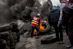 blocage devant le dépôt pétrolier de Douchy-les-Mines. Un syndicaliste de la CGT alimente le feu avec des pneus.