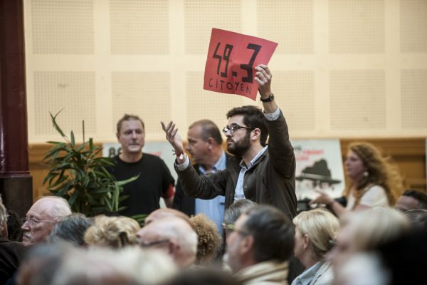 LILLE, FRANCE – JULY 4: An activist against the labor law was introduced in the meeting « Hey oh left, » brandished a poster against the use of 49-3 in Lille, France on july 4.
Supporters of the policy of the socialist government, led by Stéphane Le Foll and Patrick Kanner in the region held a meeting, « Hey oh the left » Monday night at the Lille Gymnasium, to restore confidence to the militants and provide them with arguments.