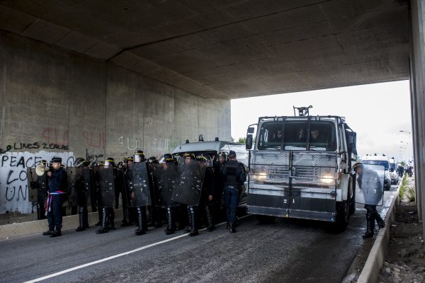 Manifestation en faveur des réfugiés. 1er octobre 2016 – Calais. La police bloque le pont à l’entrée de la jungle. Un canon à eau renforce le dispositif.